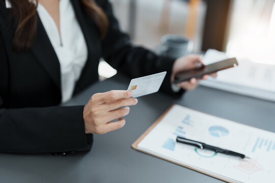 Online Shopping and Internet Payments, Asian woman are using their credit card and mobile phone to shop online or conduct errands in the digital world.