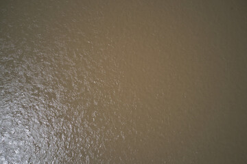Texture green brown river top view. Brown river view from above. Texture dirty water top.