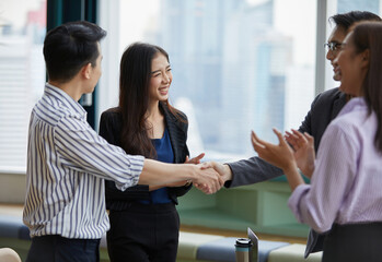 businesspeople shaking hands and clapping hands for celebrating success at work in the office