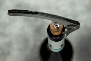 Obraz premium Bottle, corkscrew and cork on a black background. Selective focus.