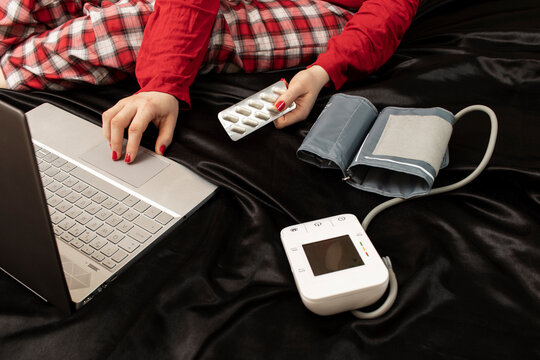 A woman searches the Internet for information about hypertension. Self-medication concept.