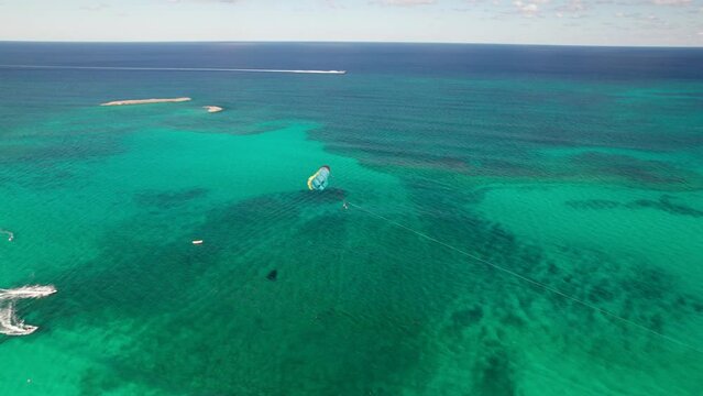 Epic drone panorama of a Parasailer over Atlantis, Paradise Island, Bahamas. Gorgeous waters, tropical vacation destination.