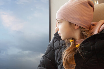 Cute little girl staring through window on a journey