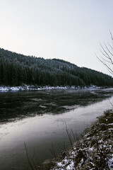 zugefrorener See am Abend im Wald mitten im Schwarzwald im Winter mit Eis und zugefrorenem See