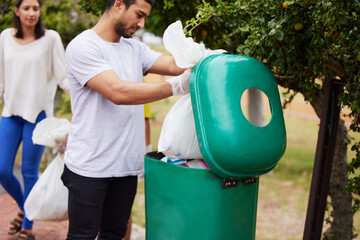 Volunteer cleaning, garbage bin and man throw trash, pollution or waste product for environment...