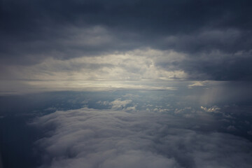 Top view of the clouds from the airplane window - storm clouds under the sun
