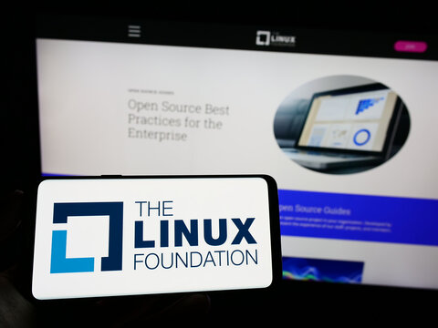 Stuttgart, Germany - 01-14-2023: Person holding cellphone with logo of technology consortium Linux Foundation on screen in front of webpage. Focus on phone display.