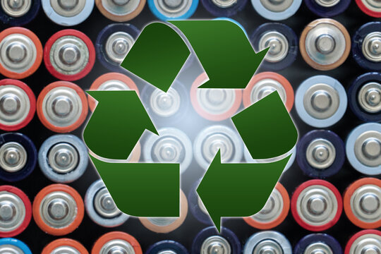 Recycling symbol on a background of used AA battery