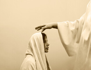 Blessing hand above the head of a woman in a headscarf