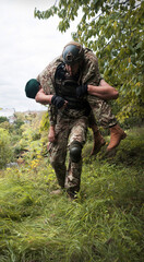 The commander carries a wounded soldier