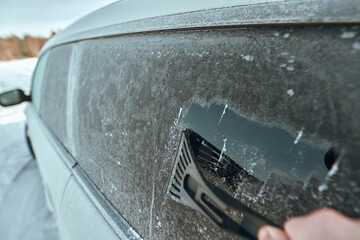 Scraping ice. Winter season vehicle glass cleaning. Clearing and removing snow and ice from car...