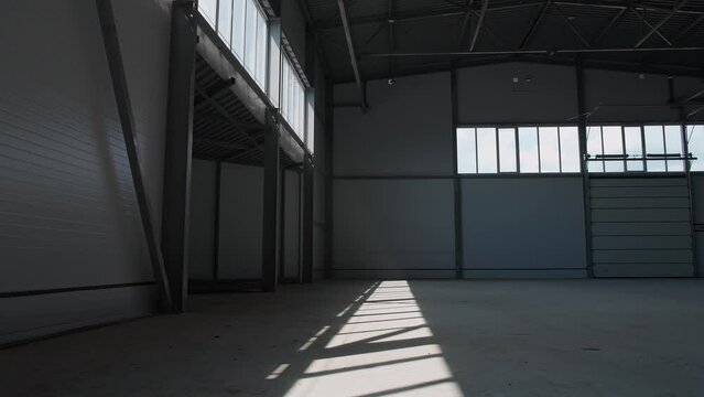 Hangar, industrial architecture, walking through the territory of an empty logistics warehouse, cinematic lighting.