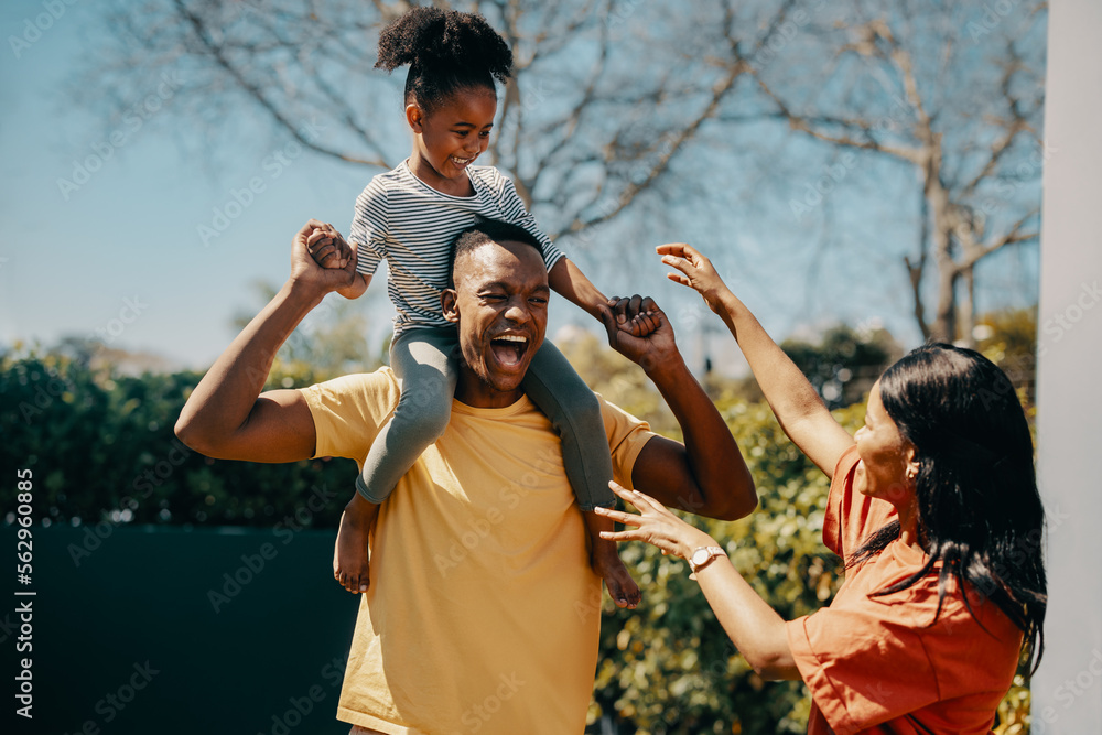 Wall mural Father carrying his daughter on his shoulders while standing outside. Parents having fun with their kid