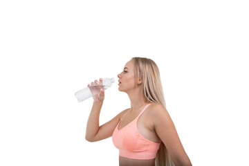 A sporty young woman in a pink top drinks water after a workout on a white background..