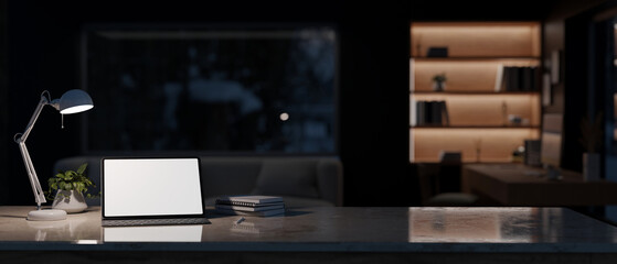 Modern contemporary home office at night with tablet mockup and copy space on tabletop.