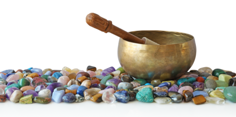 Tibetan singing bowl with mallet, resting on top of a selection of multicoloured tumbled healing stones transparent png file