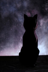Black cat silhouette over blur starry background. Vertical orientation