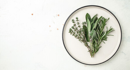 variety of fresh herbs rosemary, thyme and sage on plate. Long banner format. top view