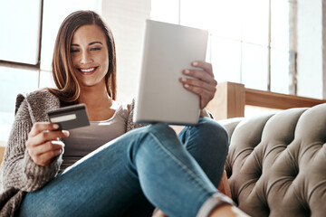 Payment, digital tablet and credit card by woman on a sofa, ecommerce and online shopping in her...