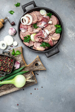 Raw chicken stomach, Traditional Korean spicy chicken gizzard with onions, garlic, chili and sesame on a gray background, place for text, top view