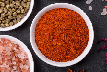 Composition consisting of variations of spices in white bowls and metal spoons