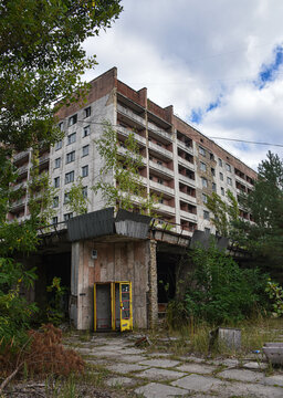 Abandoned building in Chornobyl with a phonebooth reclaimed by  nature and plants 