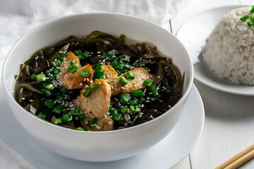 Korean seaweed soup with meat in white bowl and boiled rice. Birthday soup. Traditional Korean Cuisine. Healthy diet. Pregnancy. Custom. Close up.