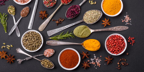 Composition consisting of variations of spices in white bowls and metal spoons