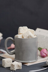 There is a cup on the table filled with handmade sweets