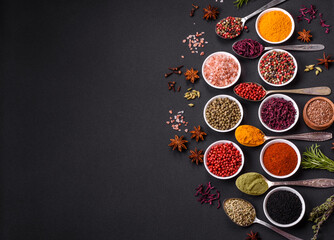 Composition consisting of variations of spices in white bowls and metal spoons