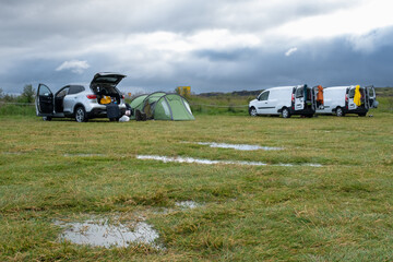A flooded camp site after heavy rain in Iceland, with puddles on the grass