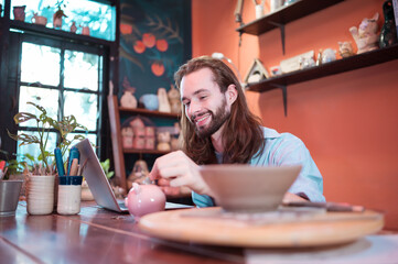 A young businessman owns a small pottery business. Are building themselves by saving money to...