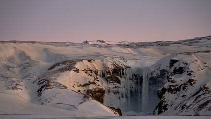 The mighty Skogafoss waterfall all frozen in the middle of cold winter, South Iceland