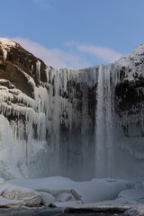 The mighty Skogafoss waterfall all frozen in the middle of cold winter, South Iceland