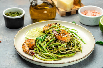 Pasta spaghetti zucchini basil pesto sauce and grilled shrimp, Vegetarian vegetable pasta, Food recipe background. Close up