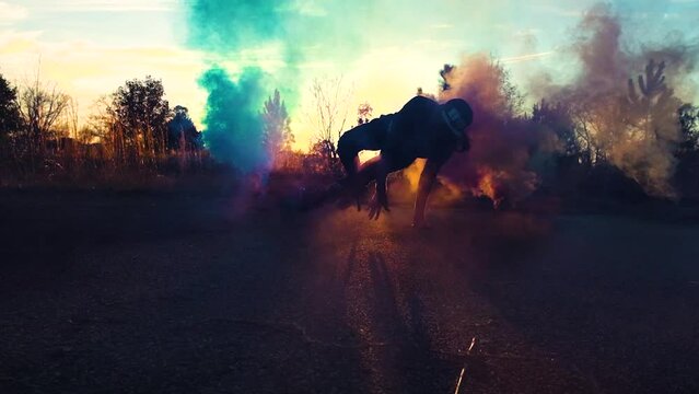 Man doing breakdance in urban scene with colored smoke high energy motion dance concept