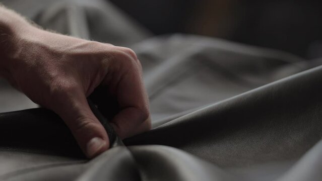 Slow motion shot man touching fine leather closeup