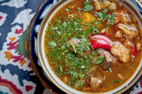 Uzbek chuchvara with tomato sauce and vegetables served in plate. Joshpara is a kind of dumpling