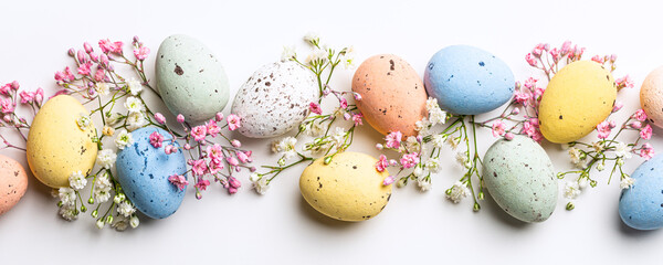 Banner of Easter quail eggs, flowers over white background. Spring holidays concept with copy...