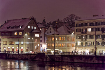 Naklejka premium Old town of City of Zürich on a late autumn night with snowfall and Limmat Quay in the background. Photo taken December 10th, 2022, Zurich, Switzerland.