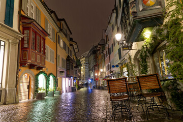 Fototapeta na wymiar Famous alley named Augustinergasse on a snowy late autumn night with beautiful decorated stores and shops at City of Zürich. Photo taken December 10th, 2022, Zurich, Switzerland.