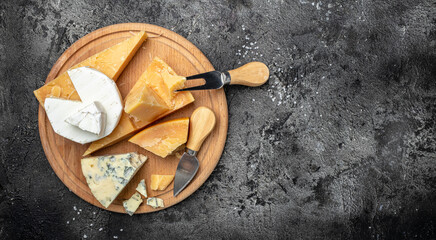 Parmesan. Different types of cheese with knife on a dark background. Cheeses set dor blu chedar camamber brie. place for text, top view