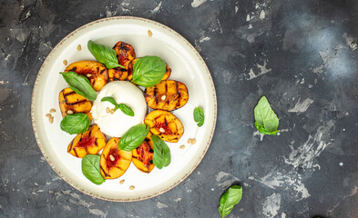Gourmet Roasted Peaches with Burrata soft cheese, basil and drizzled with honey, with rose wine. Antipasto Dinner or aperitivo party