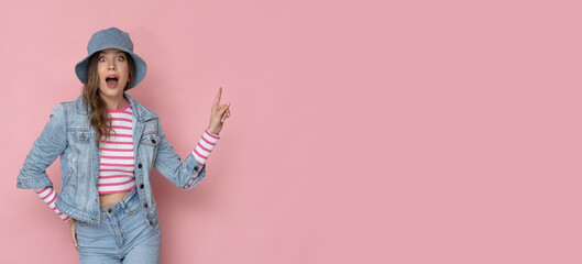 Shocked young woman in casual clothes on isolated pink background with place for text.