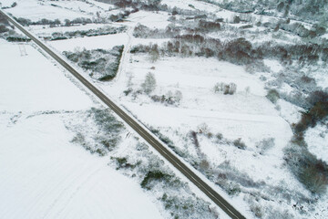 drone aerial view of a road in a snow-covered landscape, winter time concept