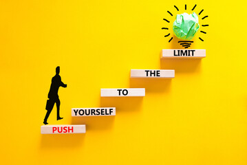 Push the limit symbol. Concept words Push yourself to the limit on wooden blocks. Beautiful yellow table yellow background. Businessman icon. Business push the limit concept. Copy space.