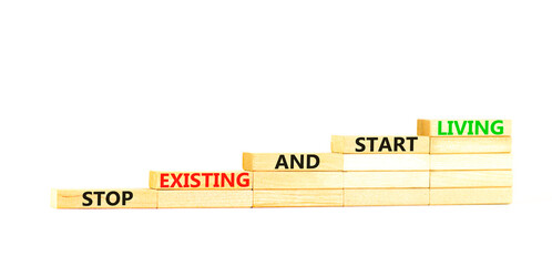 Stop existing start living symbol. Concept words Stop existing and start living on wooden blocks. Beautiful white table white background. Business Stop existing start living concept. Copy space.