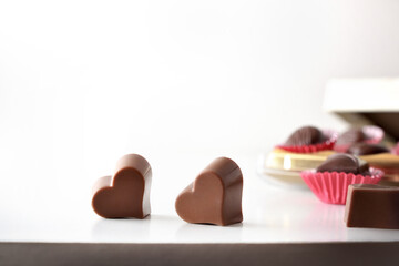 Heart shaped chocolates on white table isolated background