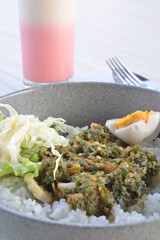 green chili squid rice with salad and pink lava drink on wooden table or in indonesia called nasi cumi cabe ijo (natural light)