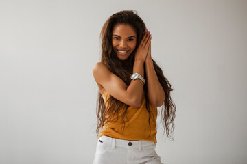 Fashion blogger wearing a orange tank top, and a white and golden wrist watch. Beautiful Portrait...